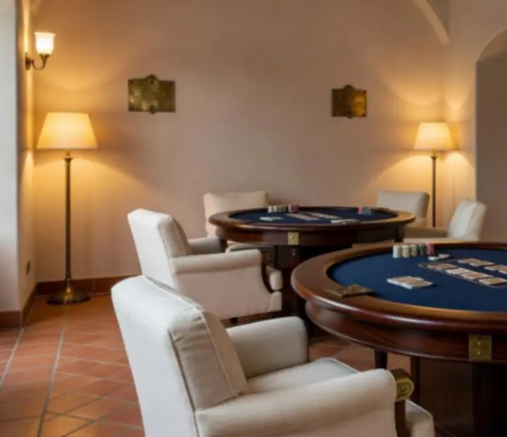 Card Lounge privado con mesas de póker, cartas y fichas preparado para partidas presenciales.